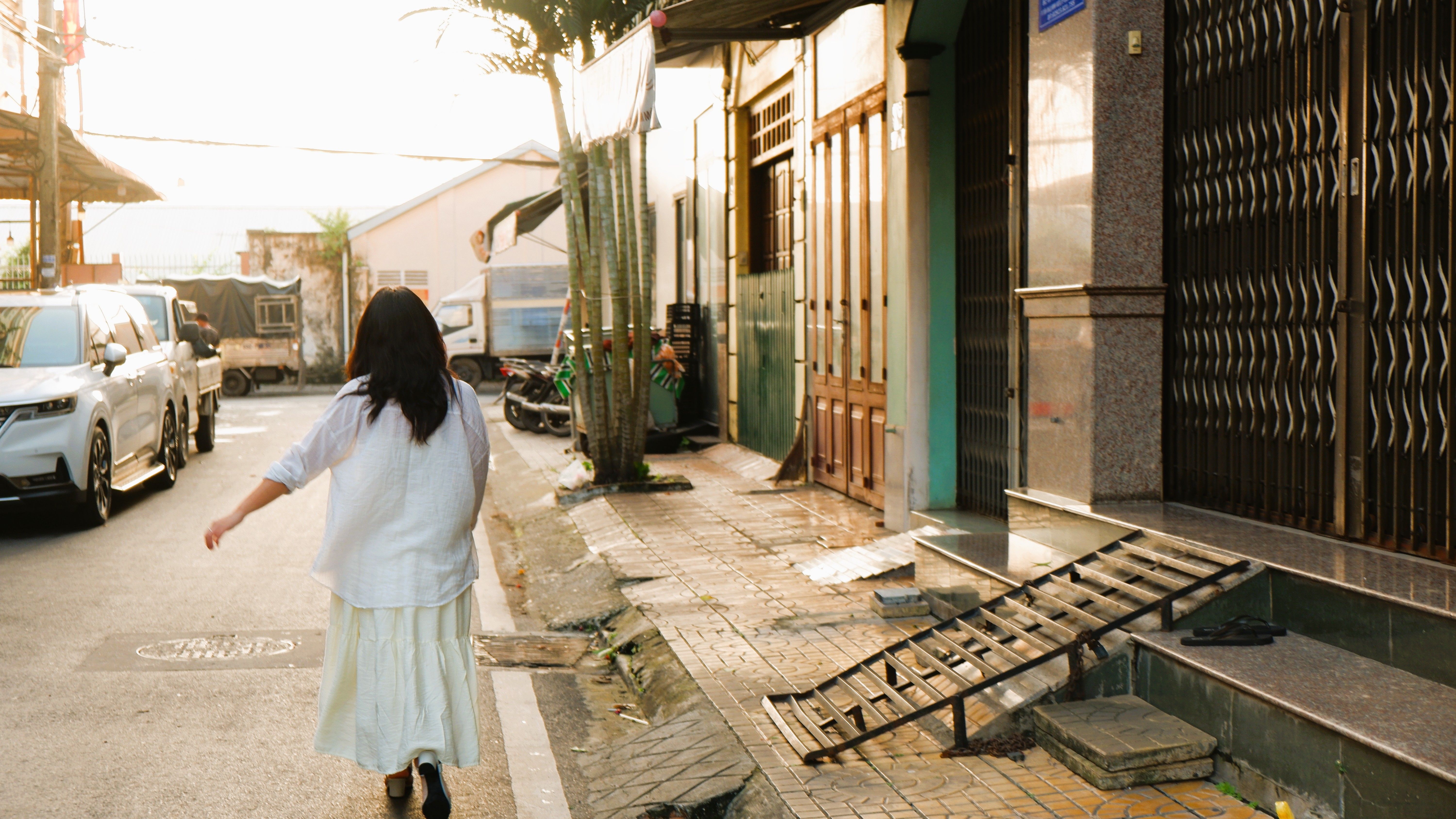 person walking on a quiet residential street at sunset with hands in pockets