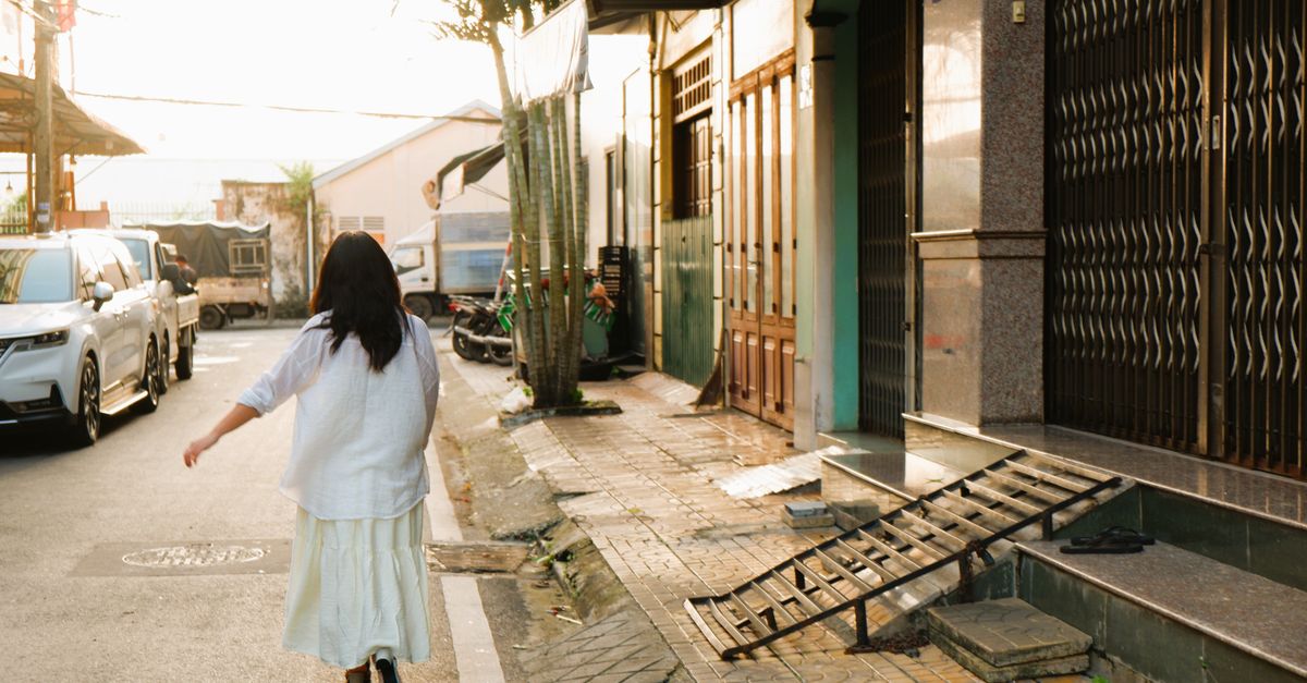 person walking on a quiet residential street at sunset with hands in pockets