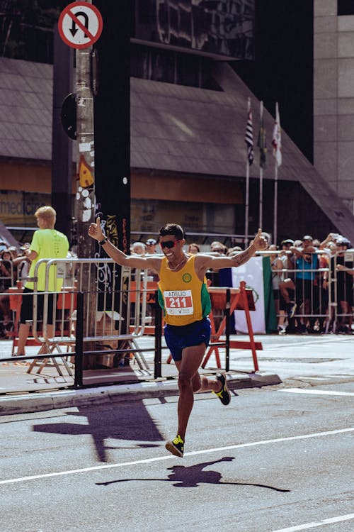 Free Man in Yellow Tank Top and Black Shorts Running on Street Stock Photo