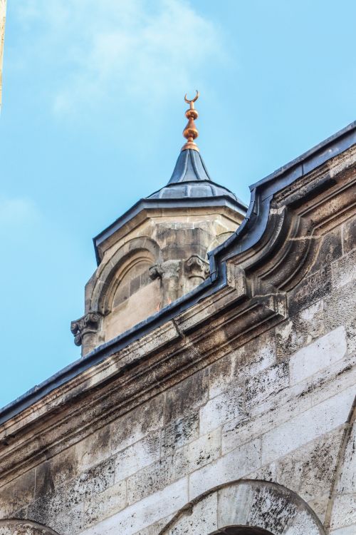 Free Close-up of a historic mosque dome with a crescent under a clear blue sky. Stock Photo