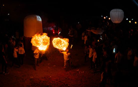 Exciting fire performance at a night festival in Chattogram, Bangladesh with vibrant lanterns.