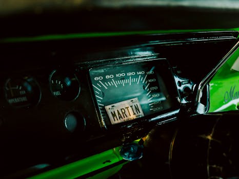 Close-up of a vintage car dashboard featuring a speedometer and unique details.