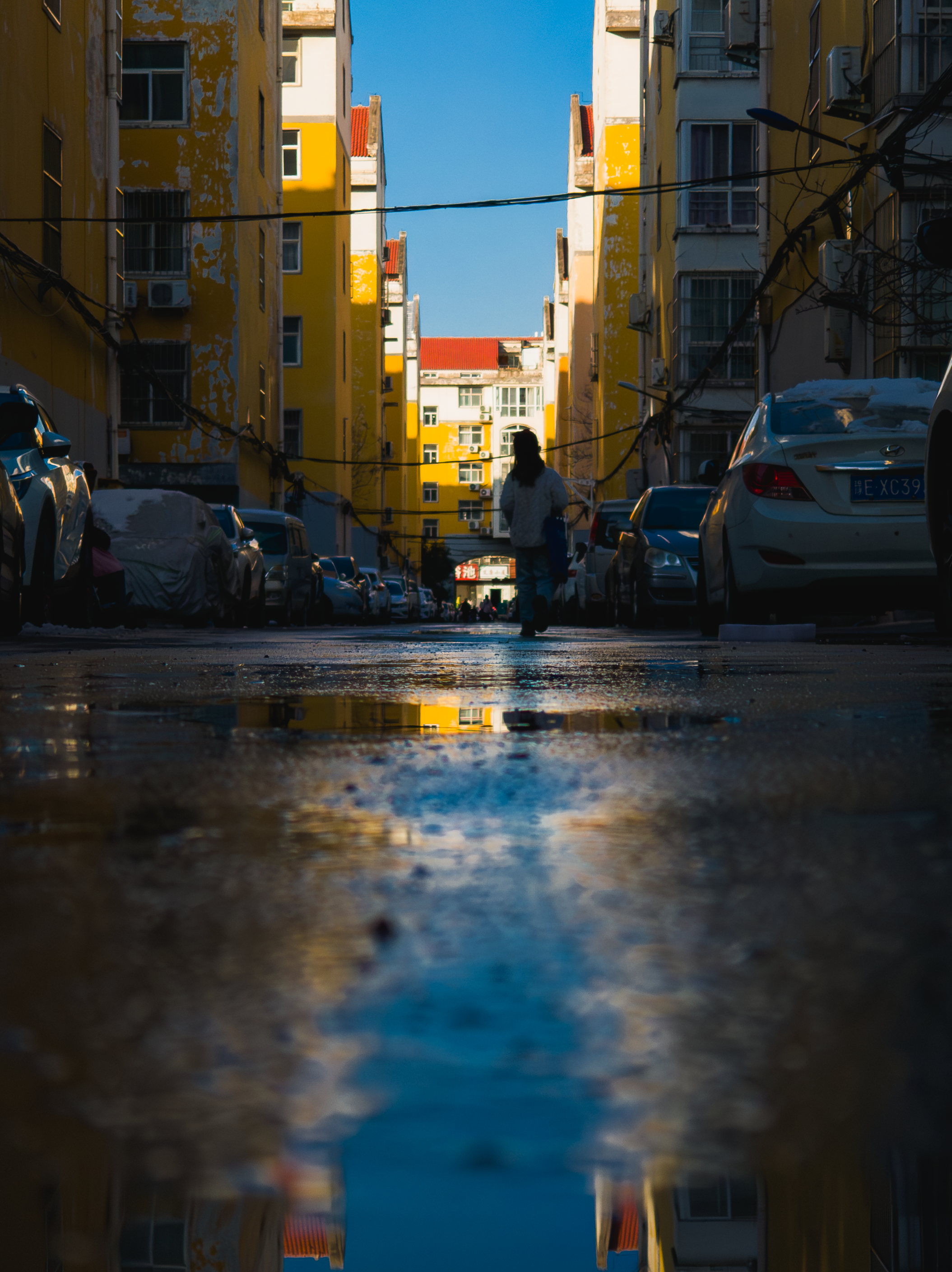 Urban Street Scene with Reflection in Puddle · Free Stock Photo
