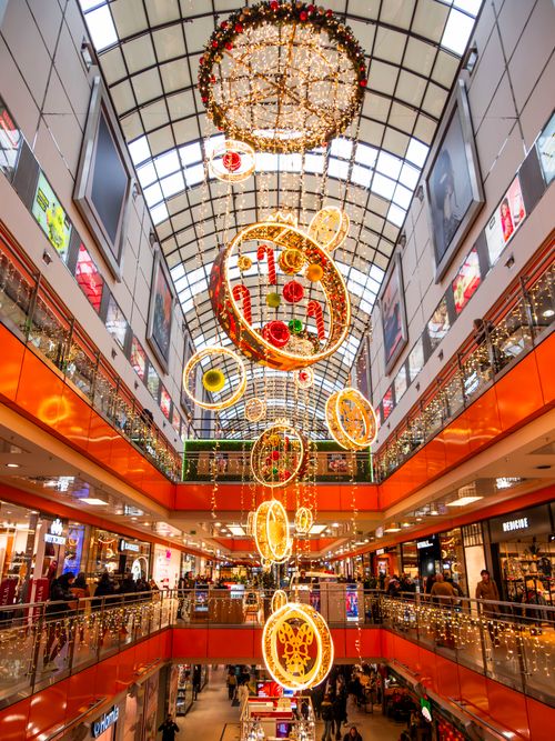 Free A vibrant shopping mall hall adorned with festive Christmas decorations and lights. Stock Photo