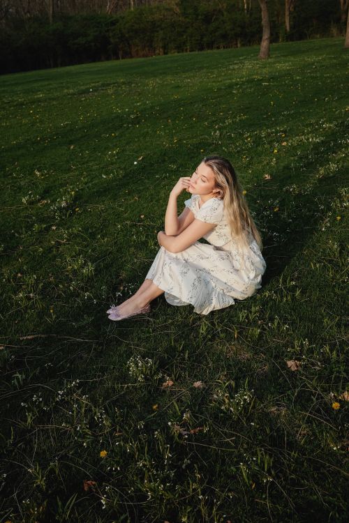Young Woman in White Dress Sitting in a Meadow · Free Stock Photo