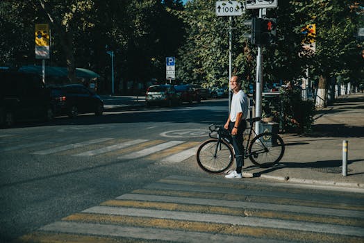 在一个阳光明媚的日子里，一名男子骑着自行车穿过了人行横道