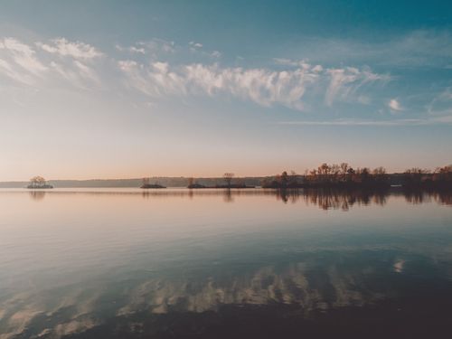 Free Serene lake landscape with reflections at sunrise, capturing autumn tranquility. Stock Photo