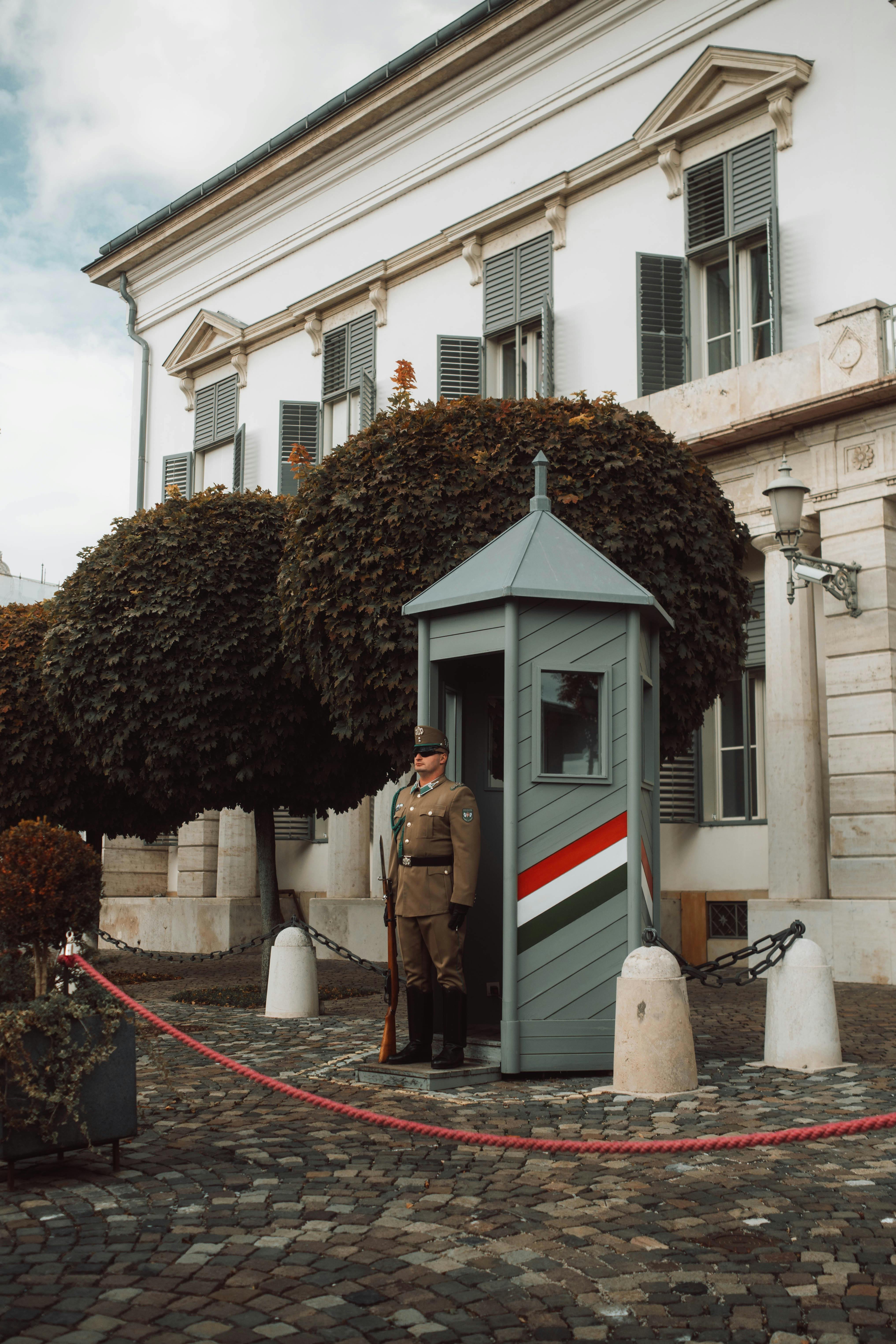 A uniformed guard stands watch at a traditional post in Budapest, Hungary.