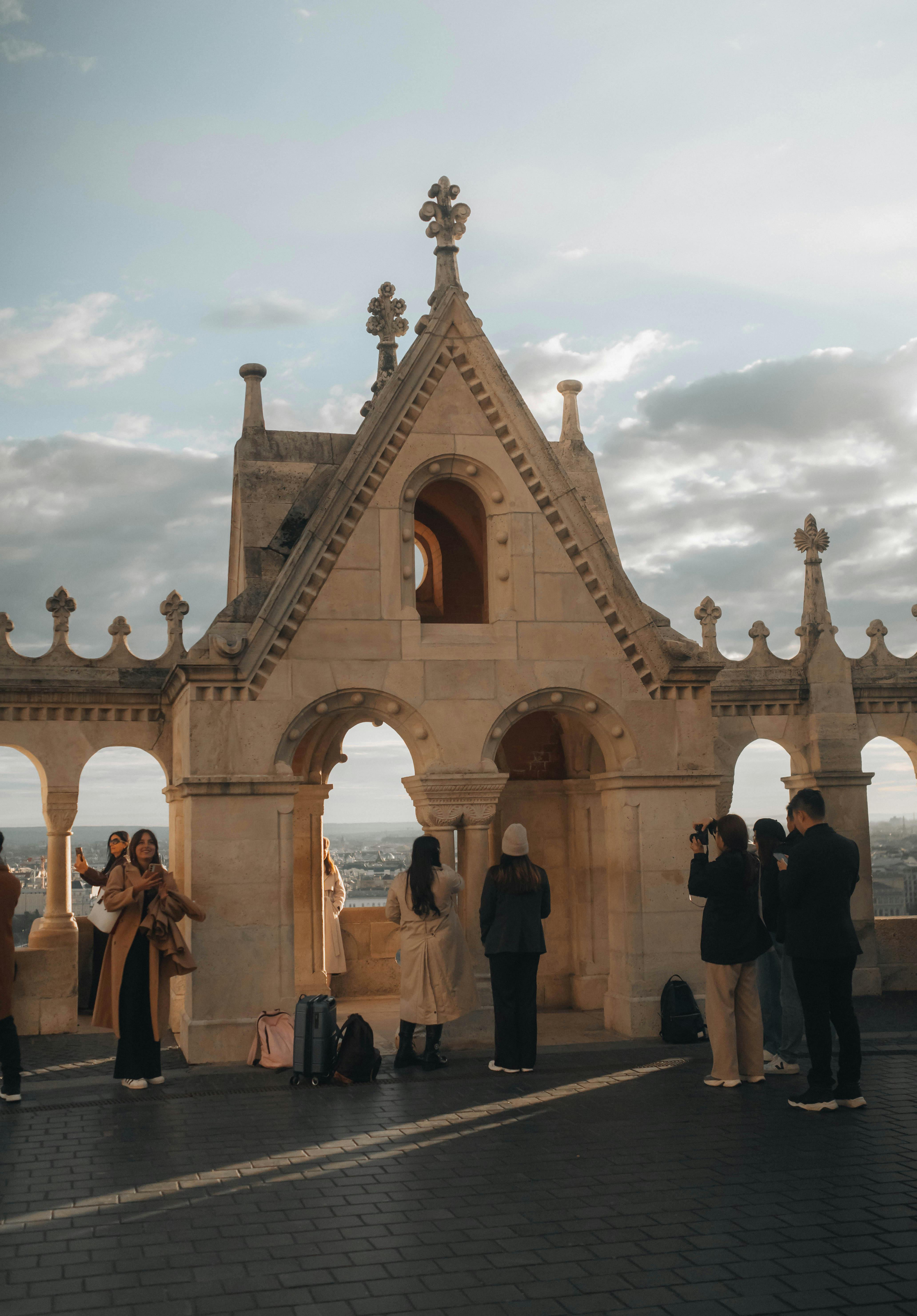 Group of tourists enjoying the view at Fisherman's Bastion, Budapest during daylight.