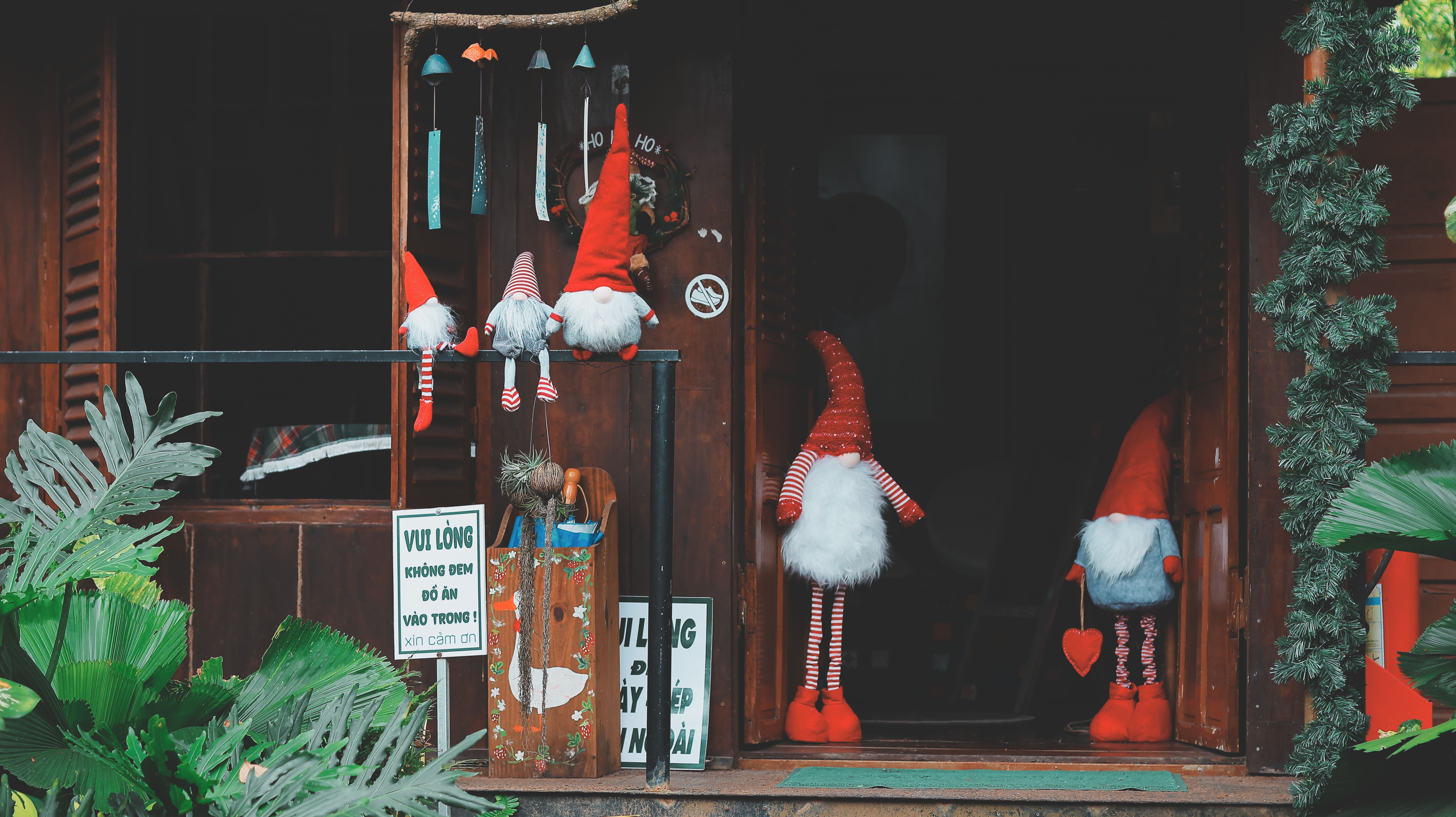 Whimsical Christmas gnomes decorating a cozy wooden entrance, creating a festive atmosphere.