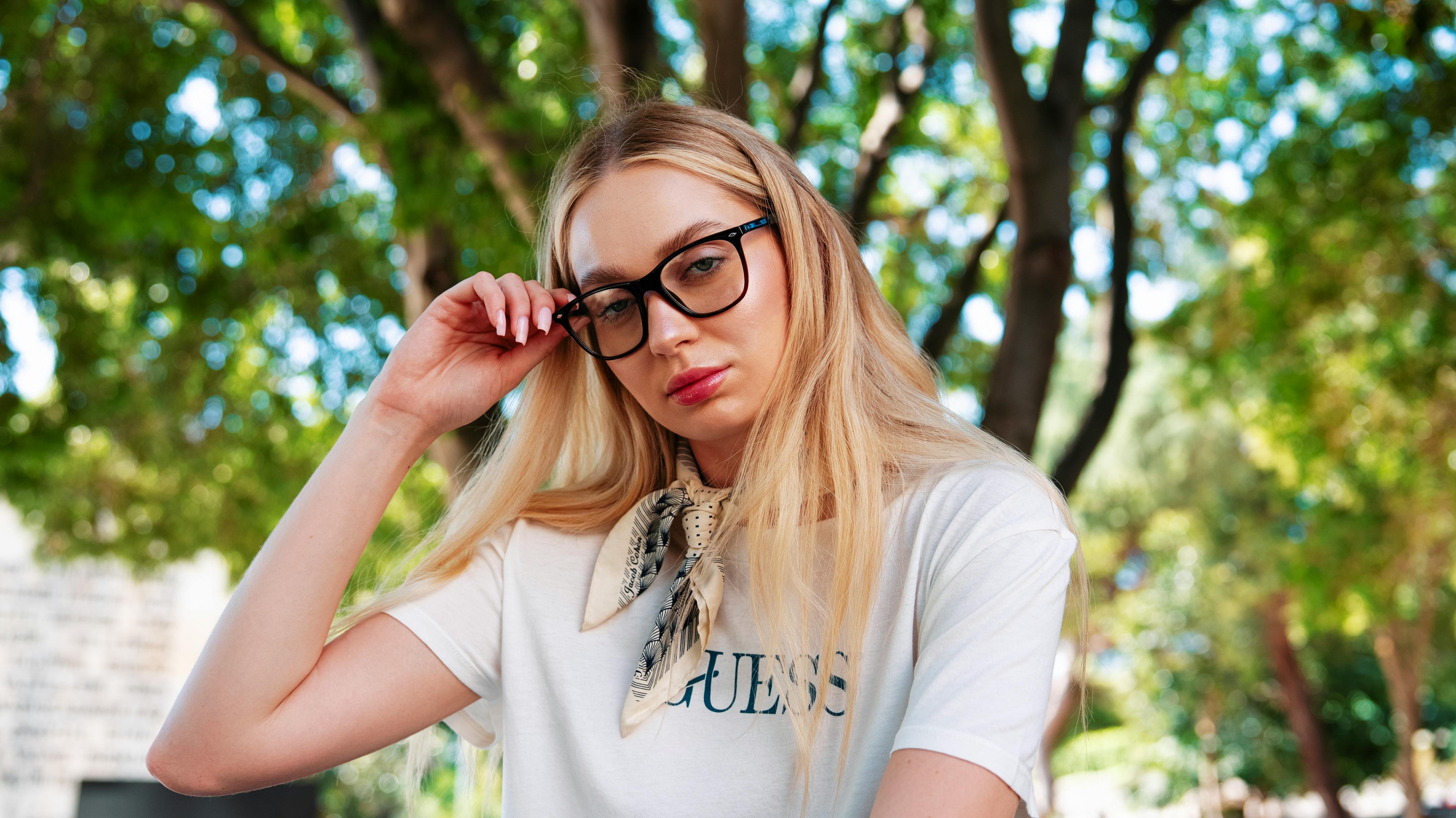 bezplatná Módní žena v brýlích pózuje venku a předvádí ležérní styl. Základová fotografie