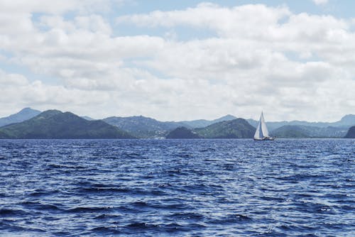 бесплатная Белая лодка с парусом на водоеме Стоковое фото