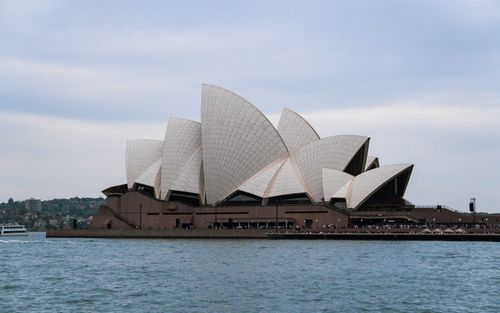 Free Iconic view of the Sydney Opera House from the harbor, showcasing its unique architecture. Stock Photo