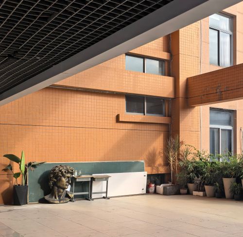 Free Open courtyard with a sculpture, potted plants, and modern architecture. Stock Photo