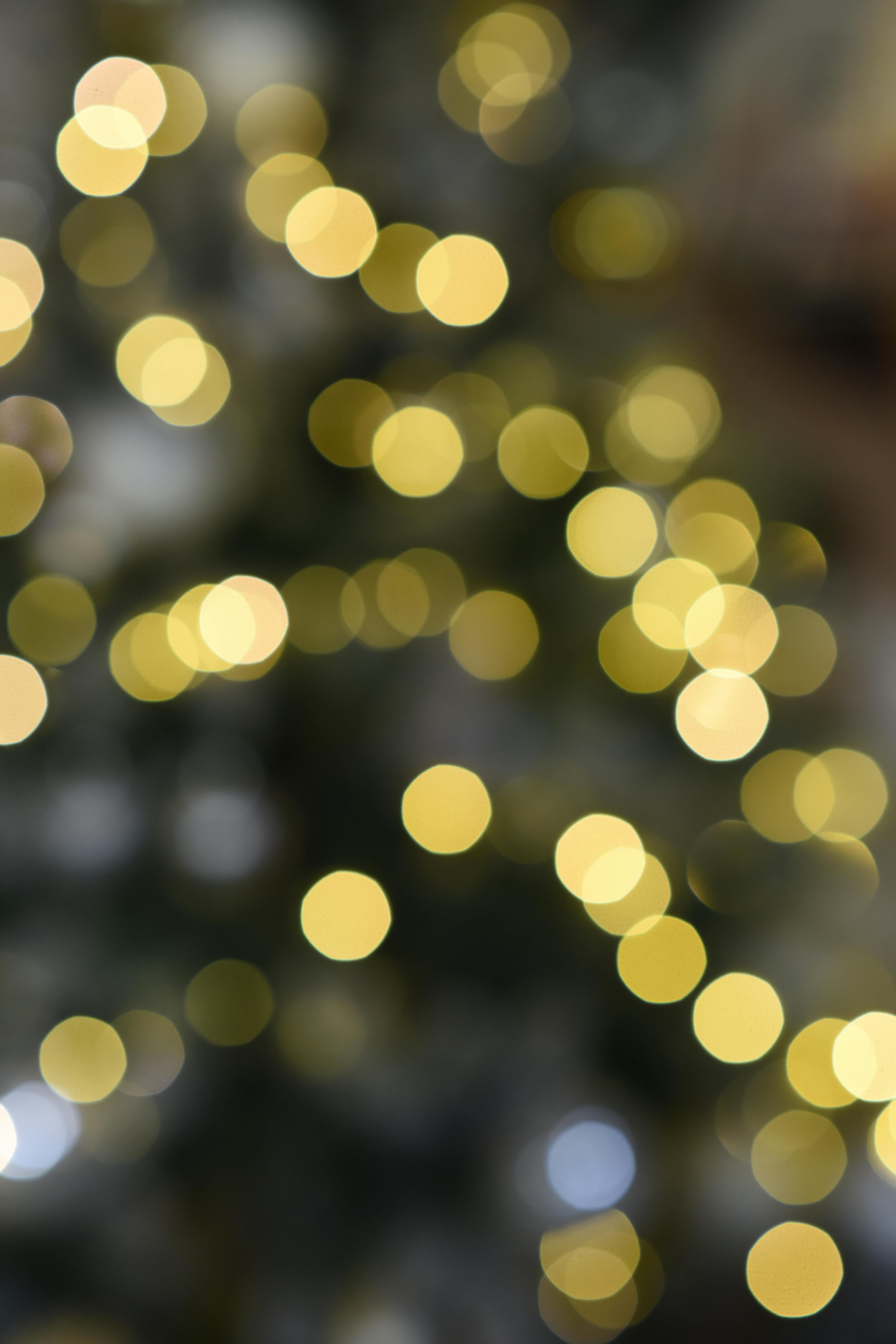 Soft golden bokeh lights create an enchanting abstract background with a warm, dreamy feel.