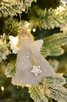 Charming angel ornament with star on a decorated Christmas tree.