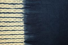 Close-up of indigo-dyed fabric featuring a wave pattern transitioning from light to dark blue.