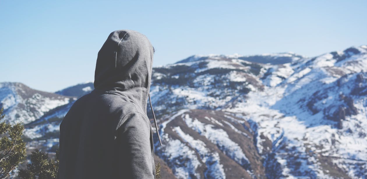 Person Standing in Front of Snow Mountains