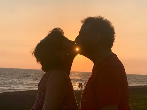 Foto profissional grátis de amor, beijando, céu alaranjado