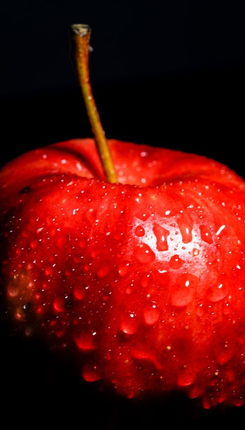 Free Close-up of a fresh red apple with water droplets on a dark background for a dramatic effect. Stock Photo
