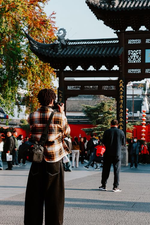Free Photographer capturing vibrant city life at Confucius Temple, Nanjing with autumn foliage. Stock Photo