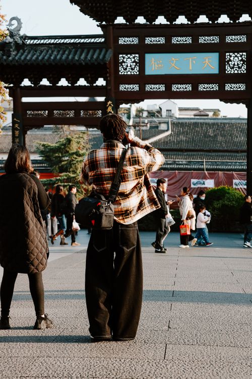 Free Candid street scene capturing photographer in motion at Confucius Temple, Nanjing, in autumn. Stock Photo