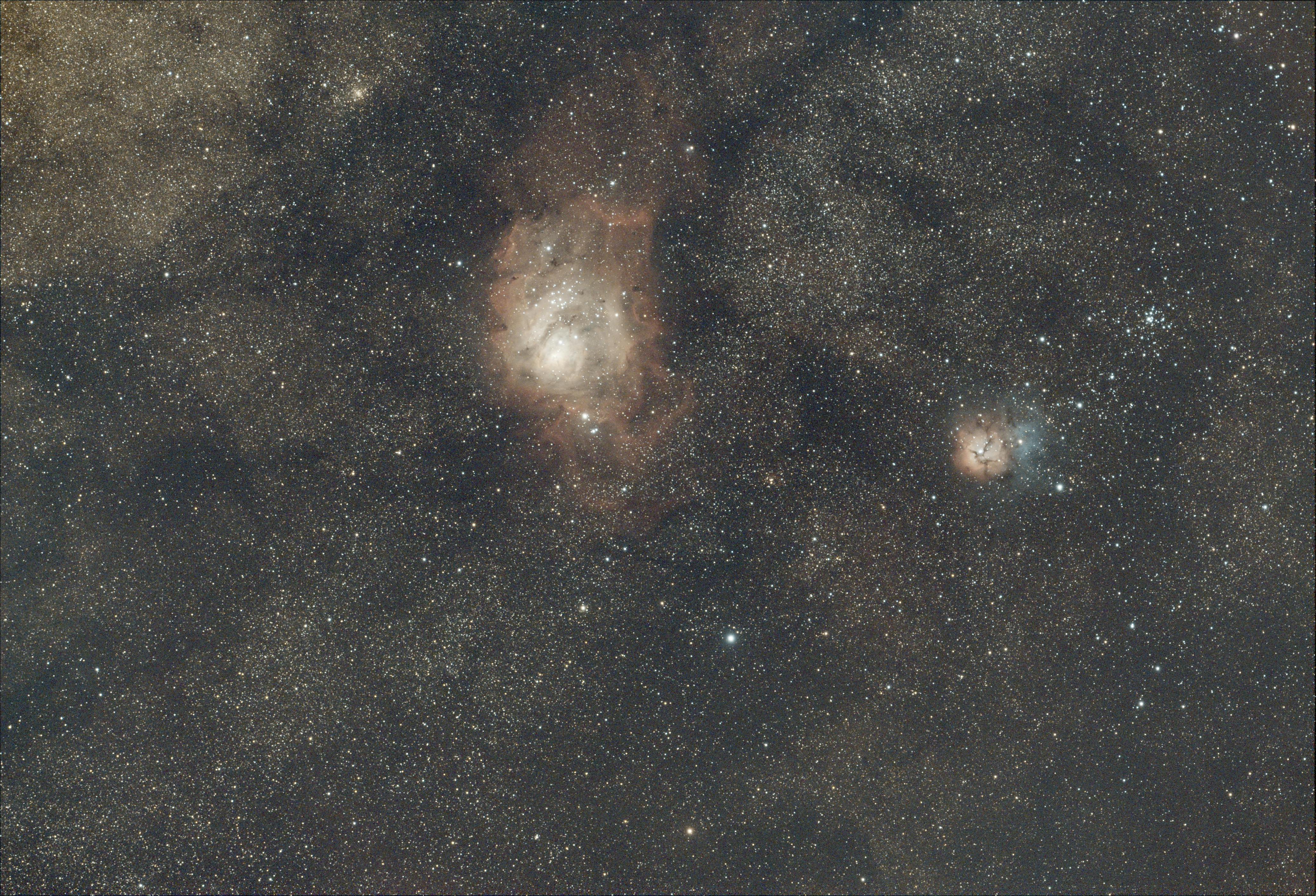 Intricate view of the Lagoon Nebula and Trifid Nebula in the starry Milky Way.