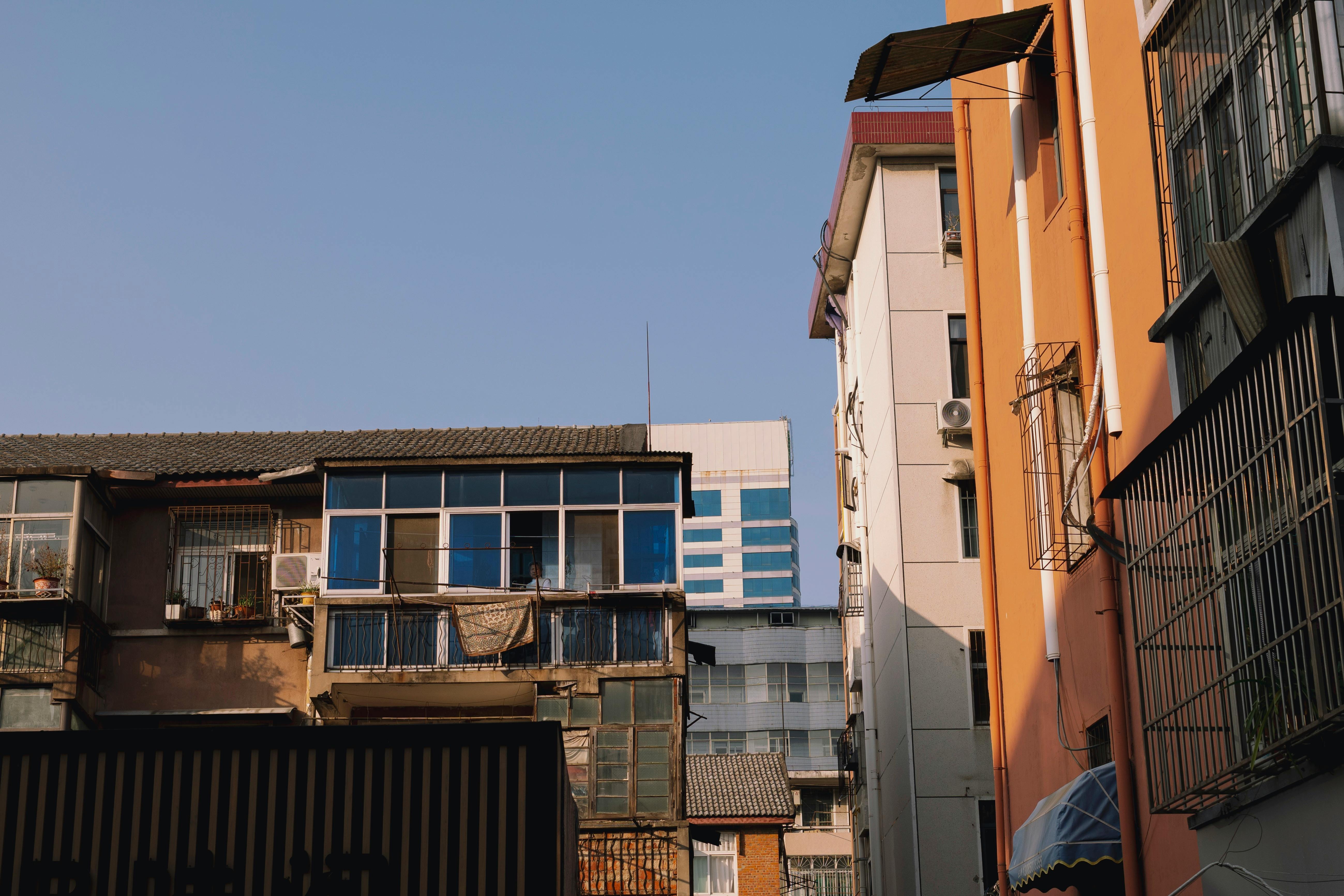 A mix of modern and old buildings in an urban setting under a clear blue sky.