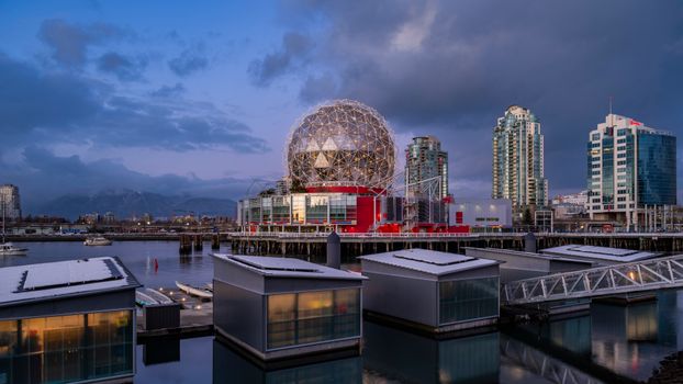Stunning view of Science World and Vancouver skyline at dusk reflecting on calm waters.
