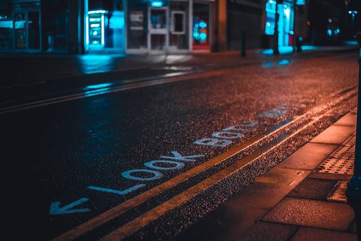 Rain-drenched street with neon light reflections and 'Look Both Ways' text.