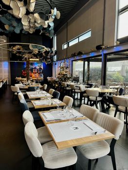 Chic and modern restaurant interior featuring elegant tables and festive decorations.