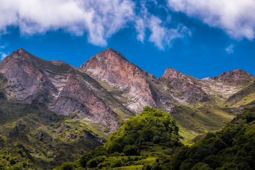 Breathtaking view of a mountain range in Occitanie, France under a vibrant blue sky.