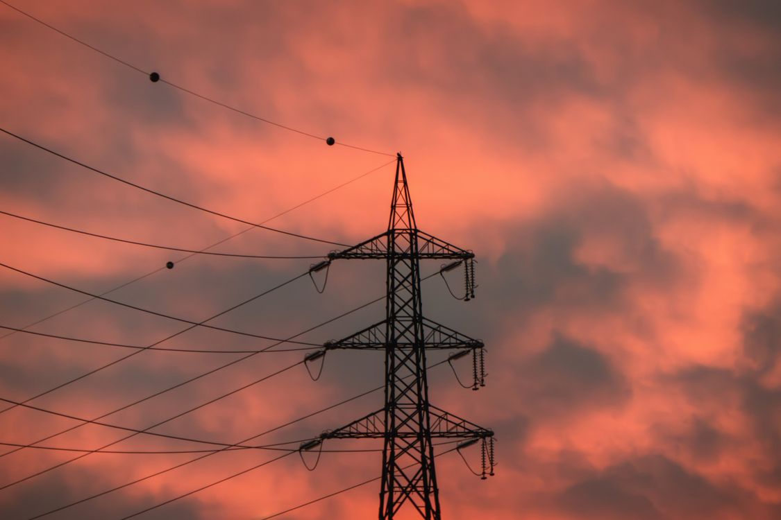 Electricity Pylon Against Dramatic Sunset Clouds · Free Stock Photo