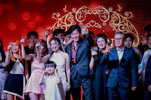 A vibrant group of people celebrating with toasts, showing happiness and unity.