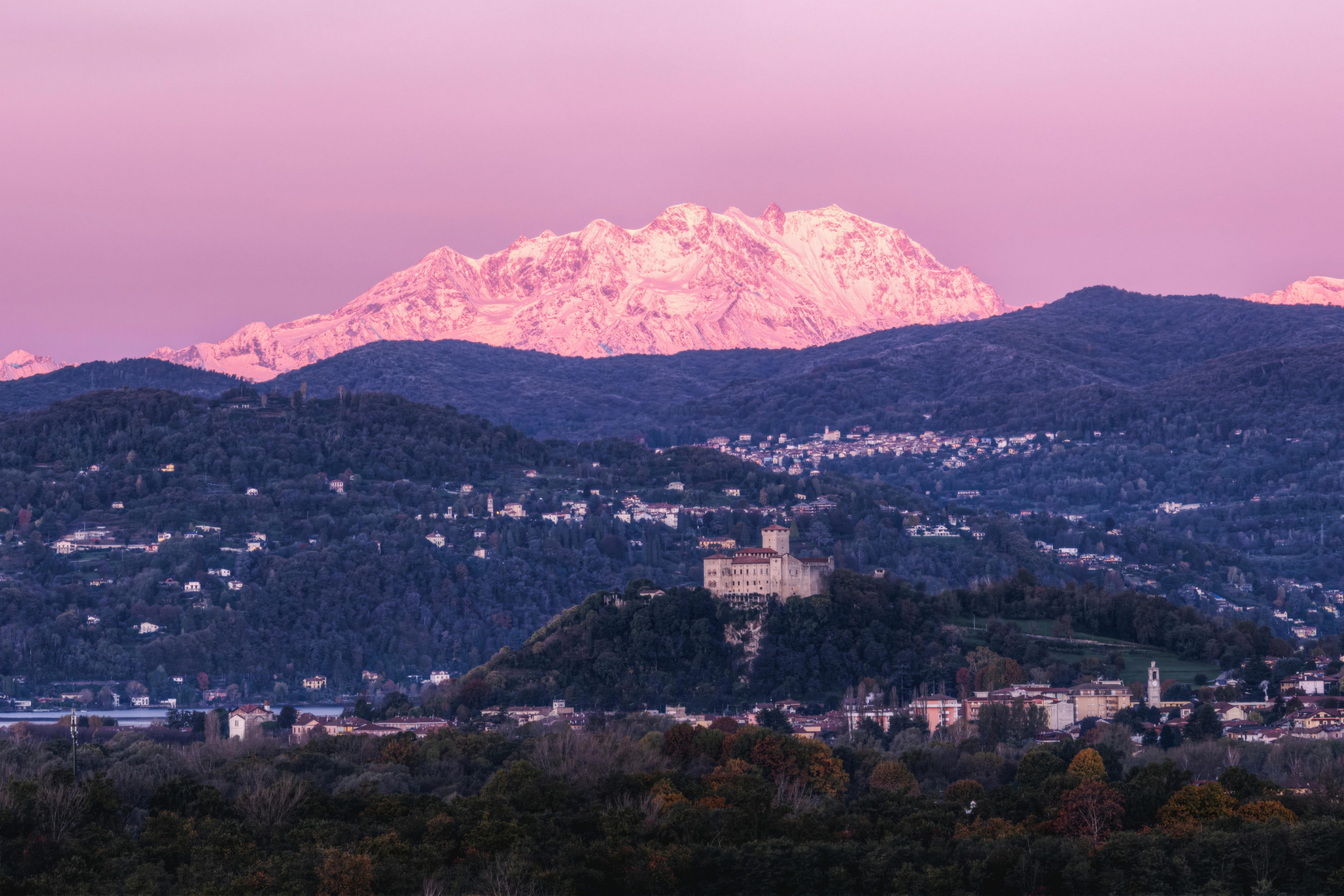 Majestic snowy Alps over Italian townscapes during sunset.