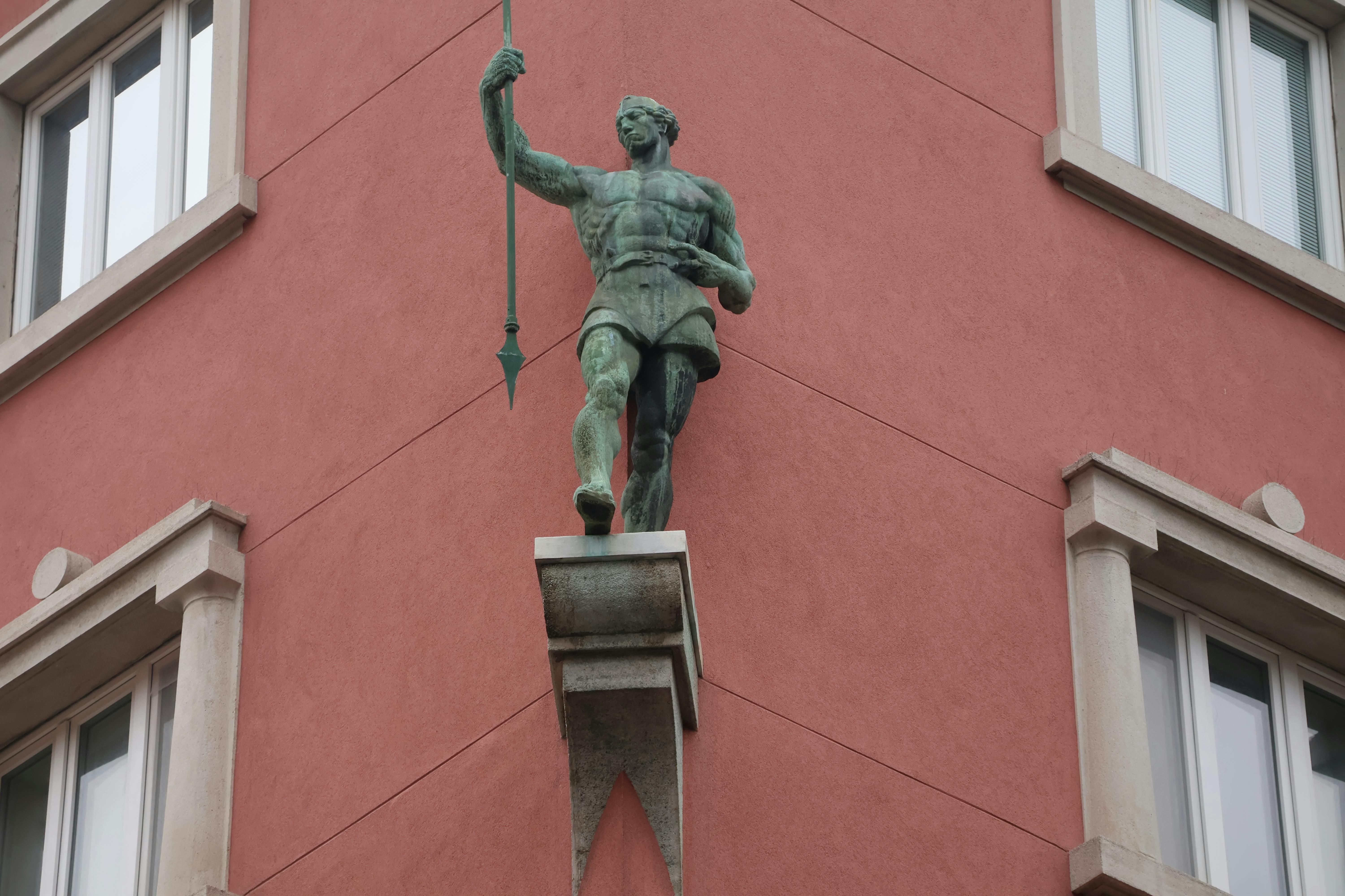 A striking statue of a warrior adorns a building facade in Ljubljana, Slovenia.