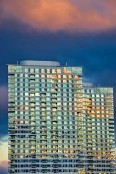 在斯洛伐克布拉迪斯拉发，高层建筑映衬着戏剧性的天空背景，反射出日落的色彩