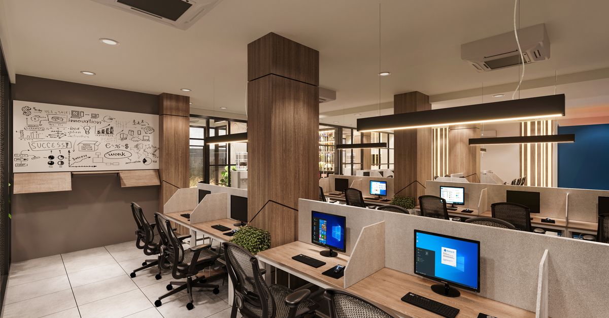 Contemporary open office space with cubicles, computers, and a creative whiteboard wall in a professional setting.
