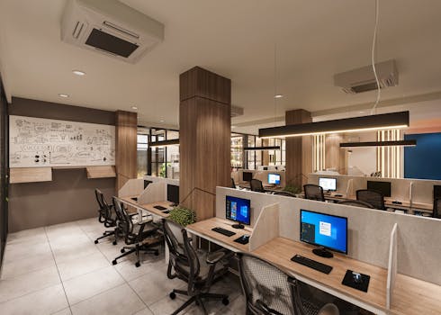 Contemporary open office space with cubicles, computers, and a creative whiteboard wall in a professional setting.