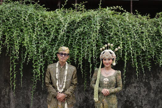 Beautiful portrait of a couple in traditional Indonesian wedding attire captured outdoors.