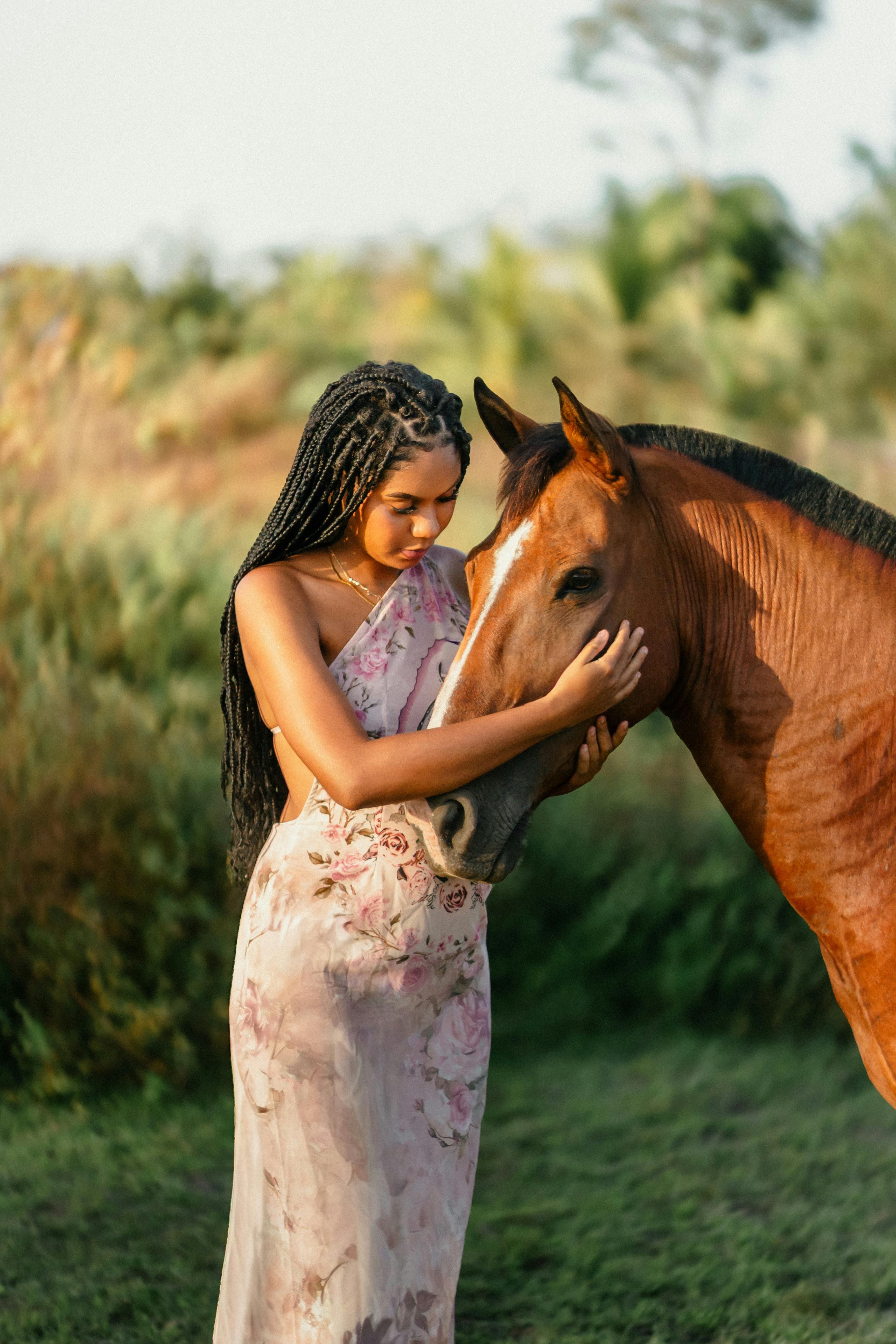 A woman gently embraces a horse in a peaceful outdoor setting, evoking tranquility.