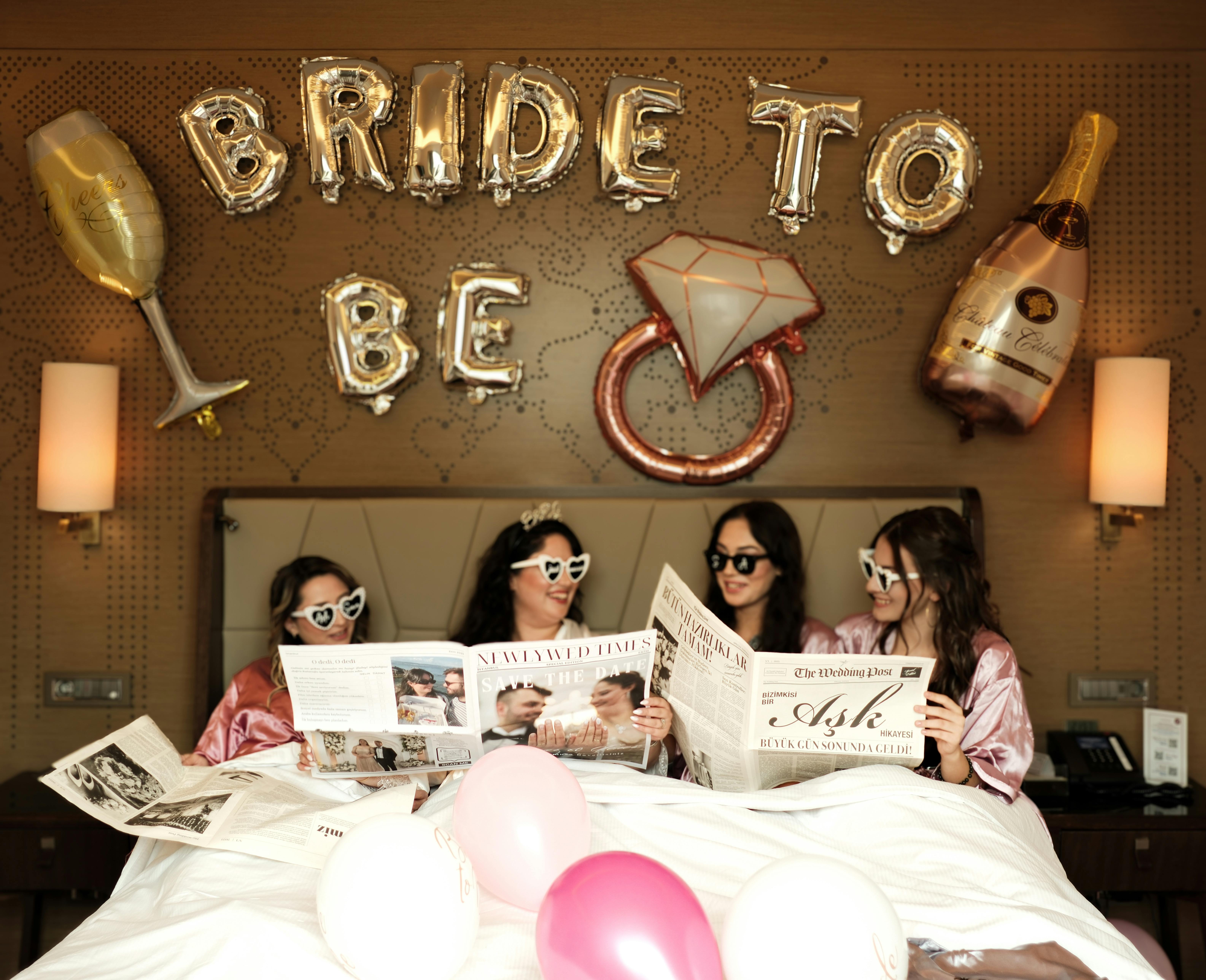 Celebrate a bachelorette party with friends, magazines, and balloons under Bride To Be decoration.