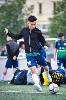 A young football player in Hà Nội practices on an outdoor field, emphasizing skill and teamwork.