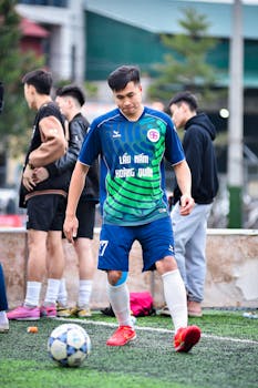 Young male soccer player practicing on an artificial turf field in Hà Nội, Vietnam.