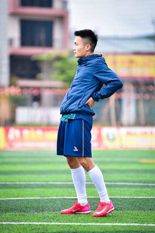 Free Side profile of a young man in sportswear standing on a football field in Hanoi, Vietnam. Stock Photo