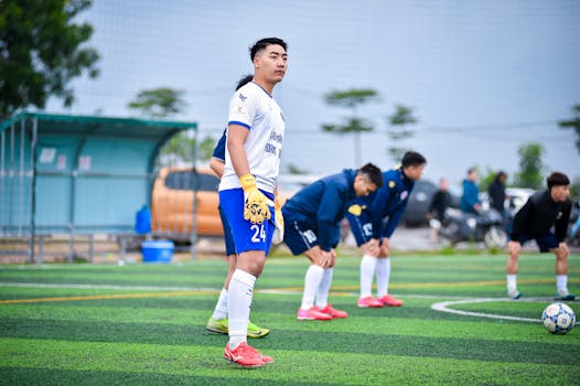 Soccer players on an artificial turf field preparing for a match in Hà Nội.