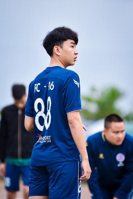 Football player in training gear on a field in Hà Nội, ready for practice.