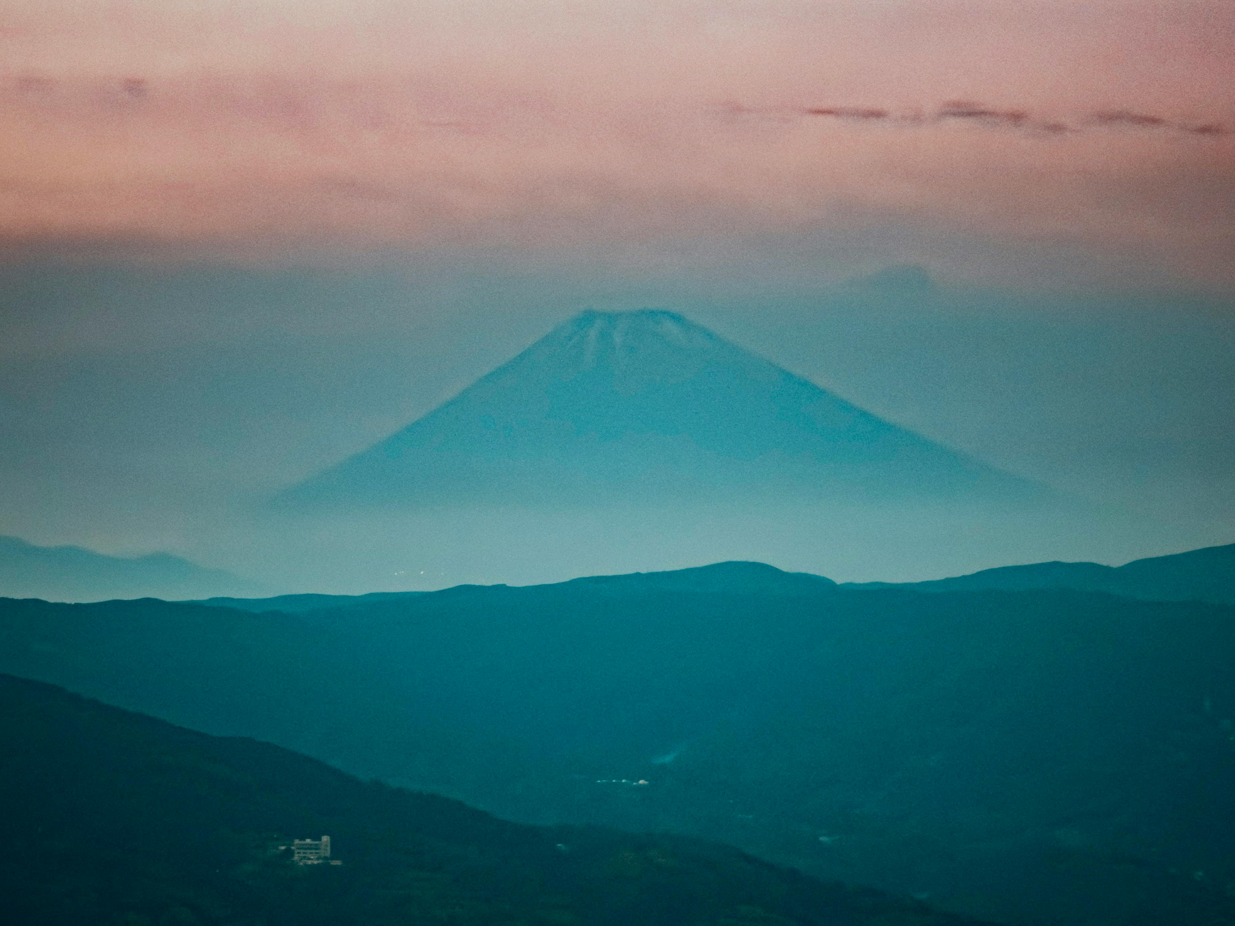 Tranquil scene capturing Mount Fuji shrouded in mist during dusk from Itō, Japan.