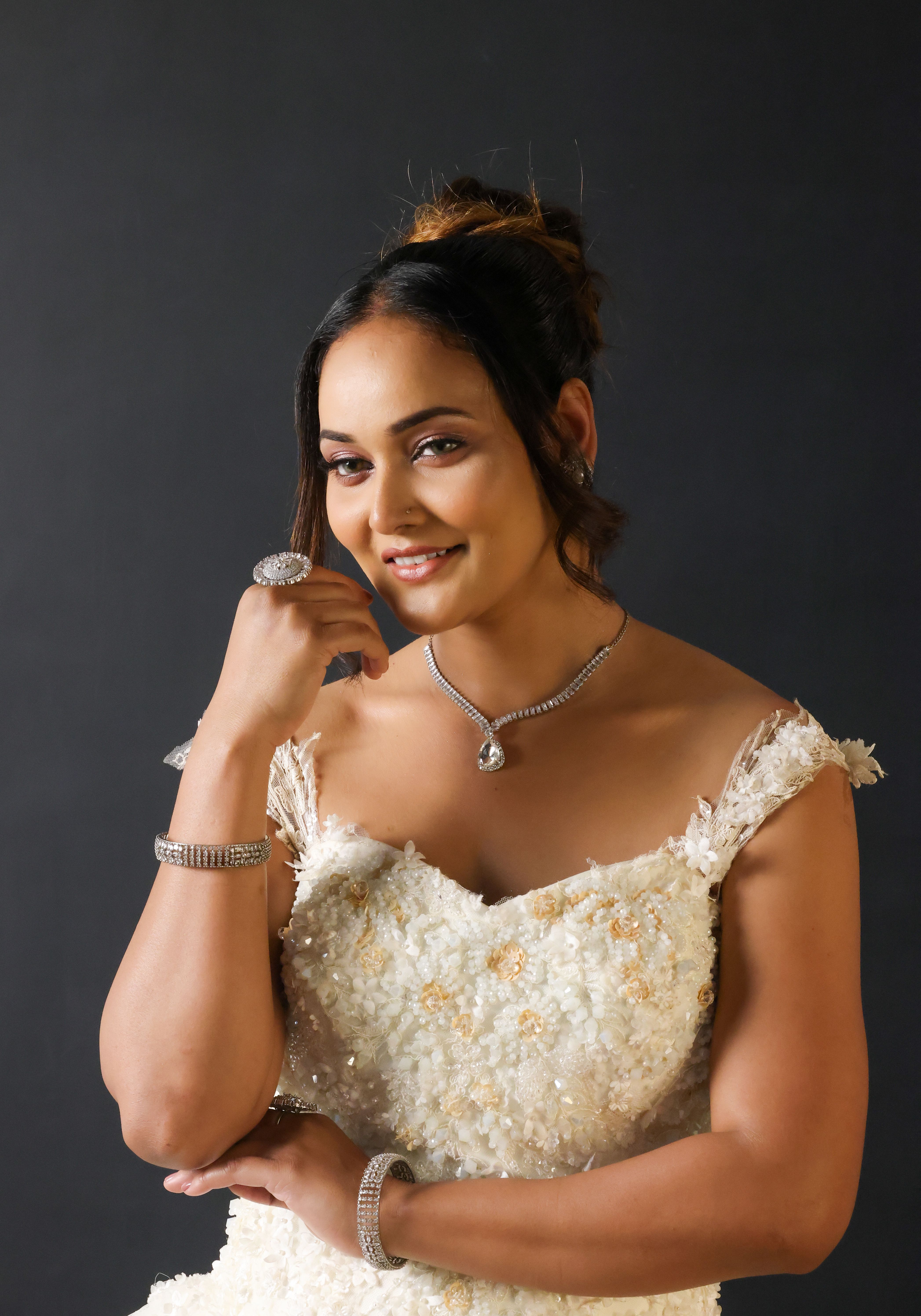 Portrait of a bride in a luxurious beaded wedding dress, adorned with elegant jewelry.
