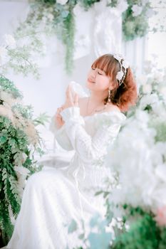 Elegant bride surrounded by lush greenery and soft blooms.